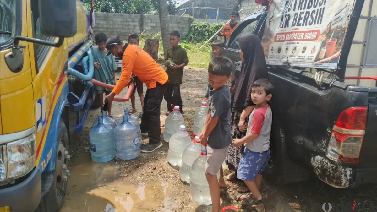 Petugas bantuan memberikan air bersih kepada warga saat situasi kemarau yang menyebabkan krisis air bersih di Depok. (Sumber: Pos Kota/ Angga)