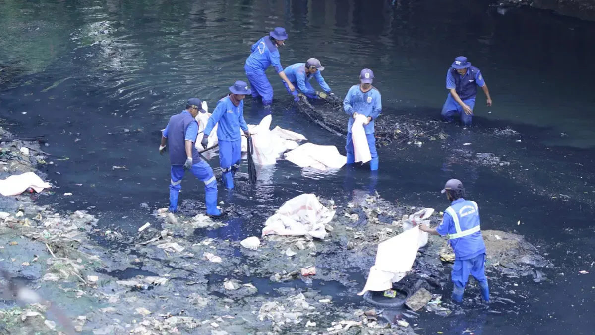 Karyawan TelkomGroup bersama petugas kebersihan saat mengangkat sampah dari aliran Kali Krukut di sekitar The Telkom Hub, Jakarta, Jumat, 18 September 2026. (Sumber: Telkom)