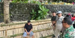 Pelaku pungli berinisial DR saat diamankan petugas karena diduga melakukan pungli di objek wisata Pantai Carita, dengan modus jembatan bambu. (Sumber: Poskota/Rahmat Haryono)