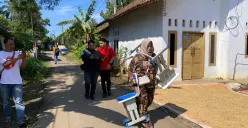 Orang tua siswa SDN 2 Pasirtangkil di Kecamatan Warunggunung, Lebak, saat memikul sepasang mebeler ke sekolah. Ia diminta pihak sekolah untuk mengganti satu set meja dan kursi yang rusak. (Sumber: Poskota/Samsul Fatoni)