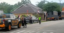 Polisi pada Senin, 18 Agustus 2025, masih berjaga di TKP bentrokan suporter usai pertandingan sepak bola tarkam di Jasinga Kabupaten Bogor. (Sumber: POSKOTA | Foto: Giffar Rivana)