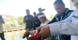 Wali Kota Bekasi, Tri Adhianto bersama Gubernur Jawa Barat, Dedi Mulyadi menuangkan air kendi sebagai simbol peletakan batu pertama pembangunan wisata air di Kalimalang, Kamis, 21 Agustus 2025. (Sumber: POSKOTA | Foto: Nurpini Aulia Rapika)