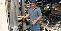 Asep, salah satu pedagang Pasar Pejuang Pratama, mengais buah jeruk miliknya yang tersisa di antara puing dan arang bekas kebakaran, Minggu 24 Agustus 2025. (Sumber: POSKOTA | Foto: Nurpini Aulia Rapika)