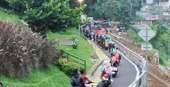 Warga melintas Jalan Saleh Danasasmita, Batutulis, Kota Bogor usai diperbaiki pasca longsor yang terjadi pada Maret lalu. (Sumber: Poskota/Giffar Rivana)