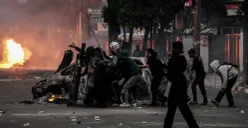 Massa aksi berlindung di balik tameng saat bentrok dengan pihak keamanan di Satuan Brimob Polda Metro Jaya, Kecamatan Senen, Jakarta Pusat, Jumat, 29 Agustus 2025. (Sumber: Poskota/Bilal Nugraha Ginanjar)
