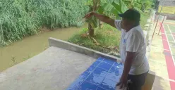 Warga menunjukan lokasi kali yang kerap menjadi penyebab langganan banjir di musim penghujan. (Sumber: Poskota/Angga Pahlevi)