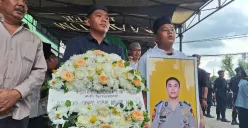 Kedua adik korban, Raihan dan Viko saat memegang karangan bunga dan foto almarhum Brigpol Iqbal Anwar Arif di Jalan Ki Ijo Bin Beih, Kelurahan Jakasetia, Kecamatan Bekasi Selatan, Kota Bekasi. Minggu, 19 Desember 2025. (Sumber: Poskota/Ihsan Fahmi)