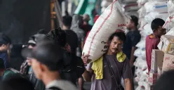 Ilustrasi - Seorang pekerja mengangkut satu karung beras di Pasar Induk Beras Cipinang, Jakarta Timur, Minggu, 29 Juni 2025. (Sumber: Poskota/Bilal Nugraha Ginanjar)