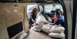 Pembeli memasukan beras ke dalam mobil, Minggu, 29 Juni 2025. (Sumber: Poskota/Bilal Nugraha Ginanjar)