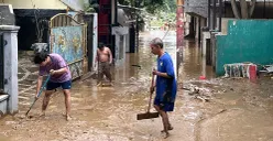 Warga RW 08 Kelurahan Pejaten Timur, Jakarta Selatan, gotong royong membersihkan lingkungan setelah banjir mulai surut pada Minggu, 6 Juli 2025. (Sumber: POSKOTA | Foto: Pandi Ramedhan)