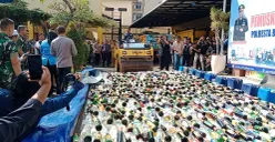 Polresta Bogor Kota bersama Forkopimda Kota Bogor memusnahkan 17 ribu botol miras hasil operasi tiga bulan terakhir di halaman Mako Polresta Bogor pada Selasa, 8 Juli 2025. (Sumber: POSKOTA | Foto: Sekar Putri Andini)