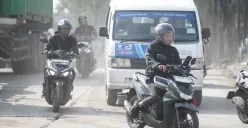 Ilustrasi pengendara motor melintasi jalan rusak. (Sumber: Poskota/Bilal Nugraha Ginanjar)