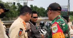 Seorang juru parkir liar di kawasan Mall Taman Anggrek Jakbar, ditegur petugas karena memakai baret TNI saat razia parkir liar. (Sumber: POSKOTA | Foto: Pandi Ramedhan)