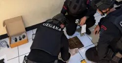 Detasemen Gegana Brimob Mabes Polri memeriksa senjata dan peluru dari koper WNA FIlipina yang menggemparkan warga Pasar Minggu, Jakarta Selatan. (Sumber: Polsek Pasar Minggu)