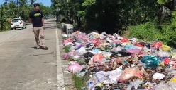 Warga mengamati tumpukan sampah di Jalan Raya Sobang-Ciseket, Desa Mekarsari, Kecamatan Panimbang, Pandeglang. (Sumber: POSKOTA | Foto: Samsul Fatoni)