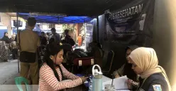 Petugas dari Pemkot Jakbar memberikan pelayanan kependudukan kepada warga Tambora yang terdampak kebakaran, Selasa, 22 Juli 2025. (Sumber: POSKOTA | Foto: Pandi Ramedhan)