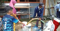 Warga Perumahan Panjibuwono, Kecamatan Babelan, Kabupaten Bekasi, mengantre untuk mendapatkan air bersih gratis dari PDAM Tirta Bhagasasi, Rabu, 14 Mei 2025. (Sumber: Poskota/Nurpini Aulia Rapika)