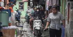 Warga melintasi genangan banjir rob di Muara Angke, Jakarta Utara, Rabu, 5 November 2025. (Sumber: Poskota/Bilal Nugraha Ginanjar)
