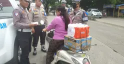 Anggota Satlantas Polresta Tangerang tengah memberhentikan pengendara motor yang tidak menggunakan helm. (Sumber: Poskota/Veronica Prasetio)