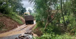 Sebuah truk melintas di jalan berlumpur dekat aliran air di Desa Cibitung, Munjul, Pandeglang. Warga menyebut material dari aktivitas tambang di area perbukitan kerap terbawa hujan dan menimbun lahan pertanian di sekitarnya. (Sumber: Istimewa)