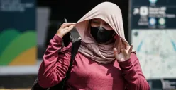 Warga berjalan di tengah cuaca terik di Jalan Jenderal Sudirman, Jakarta. (Sumber: Poskota/Bilal Nugraha Ginanjar)