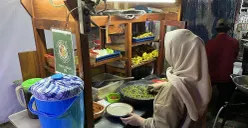 Hanifah, pedagang ayam penyet sambel ijo di kawasan Palmerah, Jakarta Barat, saat sedang melayani pembeli, Rabu, 10 September 2025. (Sumber: POSKOTA | Foto: Pandi Ramedhan)