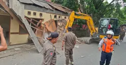Alat berat beko Satpol PP Kota diturunkan membongkar bangunan Pos Pol Kelurahan Pasir Putih melanggar Garis Sepadan Sungai (GSS) Jalan Pasir Putih. (Sumber: Pos Kota/ Angga)