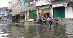 Warga Muara Angke, Jakarta Utara terobos banjir rob untuk beraktivitas. (Sumber: Pos Kota/Ali Mansur)