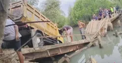 Mobil truk pengangkut pasir terperosok ke sungai saat melintasi jembatan di Kampung Citoke, Desa Mekarsari, Kecamatan Panimbang, Kabupaten Pandeglang. (Sumber: Pos Kota/ Samsul Fatoni)