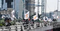 Pengendara sepeda motor melintas di dekat bendera partai politik yang terpasang di Jalan Layang Kemanggisan dan Jalan Pejompongan, Jakarta, Jumat, 6 Februari 2026. (Sumber: Poskota/Bilal Nugraha Ginanjar)