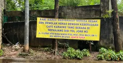 Spanduk penolakan warga terkait adanya aktivitas hiburan malam di gubuk-gubuk pinggir Tol JORR W2. (Sumber: Poskota/Pandi Ramedhan)