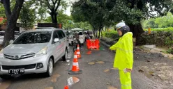 Petugas kepolisian mengatur kendaraan yang lewati jalan rusak di Jalan Juanda, Sukmajaya, Kota Depok, Rabu, 21 Januari 2026. (Sumber: Dok. Polres Metro Depok)