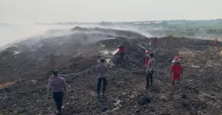 Petugas gabungan saat memadamkan api di TPA Jatiwaringin. (Sumber: Poskota/Veronica)