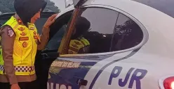 Kompol Darmawati, Kepala Induk PJR BSD Korlantas Polri, membantu mengevakuasi ibu hamil ke mobil patroli setelah kendaraan yang ditumpanginya mengalami overheat di KM 06 Ruas Tol BSD, Senin (13/7/2026). (Sumber: Istimewa)