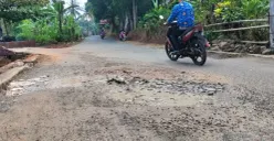 Ruas jalan Cimedang-Cisaat di Desa Alaswangi, Kecamatan Menes, Pandeglang, yang dibangun melalui program Bang Andra terlihat sudah rusak. (Sumber: Poskota/Samsul Fatoni)