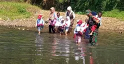 Para siswa SD di Desa Padahayu, Kecamatan Cikedal, Pandeglang, saat hendak menyebrangi sungai menuju sekolah. (Sumber: Poskota/Samsul Fatoni)