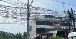 Warga sedang membenahi kabel menjuntai akibat tersenggol truk besar di Jalan Peta Selatan dan Jalan Peta Barat, Kalideres, Jakarta Barat, Selasa 23 Juni 2026. (Sumber: Poskota/Pandi Ramedhan)