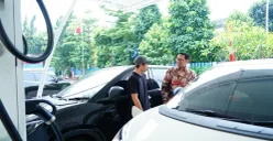 Senior Manager Niaga dan Manajemen Pelanggan PLN UID Jakarta Raya, Wira Bhakti Dharma berbincang dengan pengguna mobil listrik yang tengah mengisi daya kendaraannya di SPKLU Kantor PLN UP3 Cempaka Putih. (Sumber: Dok. PLN UID Jakarta Raya)