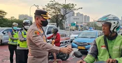 Kapolres Metro Depok, Kombes Pol Christian Rony Putra membagikan masker kepada pengguna kendaraan bermotor tidak bermasker di jalan. (Sumber: Polres Metro Depok)