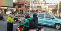 Petugas Lantas Polsek Cinere membagikan masker ke pengguna jalan di Jalan Raya Cinere. (Sumber: Satlantas Polsek Cinere)