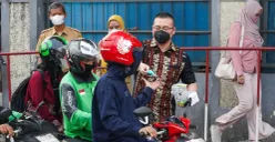 Anggota Komisi C DPRD DKI Jakarta, Hardiyanto Kenneth saat membagikan masker kepada pengendara motor dan pejalan kaki di Latumenten, Jakarta Barat. (Sumber: Istimewa)