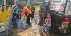 Petugas bantuan memberikan air bersih kepada warga saat situasi kemarau yang menyebabkan krisis air bersih di Depok. (Sumber: Pos Kota/ Angga)