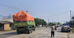 Petugas Polsek Jawilan mengarahkan kendaraan dump truk yang parkir di bahu jalan untuk mengisi kantong-kantong parkir. (Sumber: Polsek Jawilan)
