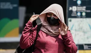Warga berjalan di tengah cuaca terik di Jalan Jenderal Sudirman, Jakarta. (Sumber: Poskota/Bilal Nugraha Ginanjar)