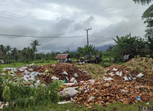 Jalan longsor di Desa Cilabanbulan, Kecamatan Menes, Kabupaten Pandeglang, terlihat sudah hampir rata diurug dengan limbah kelapa muda. (Sumber: Poskota/Samsul Fatoni)