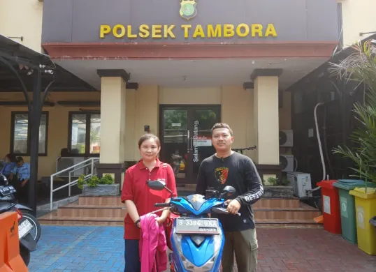 Jo Marlisa berpose bersama anggota Polsek Tambora usai motornya yang sempat dicuri berhasil ditemukan dan dikembalikan oleh pihak kepolisian. (Sumber: Dok. Polres Jakarta Barat)