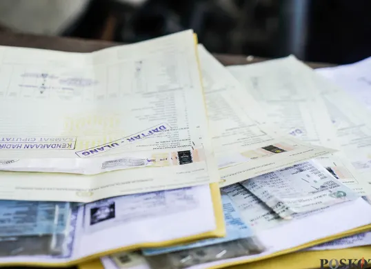 Petugas melakukan pemeriksaan fisik kendaraan wajib pajak untuk pengurusan pembayaran pajak kendaraan bermotor. (Sumber: Poskota/Bilal Nugraha Ginanjar)