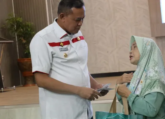 Wali Kota Bekasi Tri Adhianto saat memberikan santunan kepada seorang ibu dalam program Kota Bekasi Sayang Bunda.