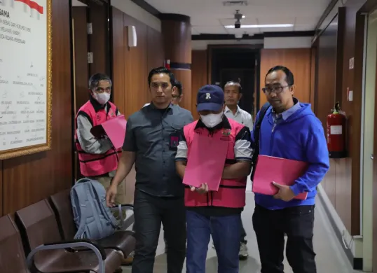 Hakim Pengadilan Negeri Jakarta Pusat Ali Muhtarom (bermasker putih dan bertopi biru dongker) ditetapkan sebagai tersangka kasus suap putusan lepas perkara korupsi CPO. (Sumber: Dok. Kejagung)