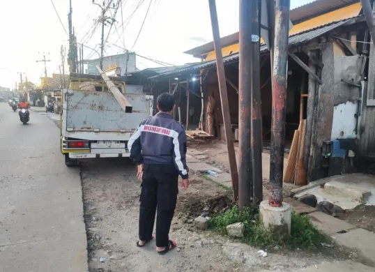 Petugas Bhabinkamtibmas berdiri di dekat tiang listrik tempat tiga petugas pemasangan tiang Wi-Fi tersengat listrik tegangan tinggi hingga tewas, di Kabupaten Bogor, Rabu, 24 April 2025. (Sumber: Dok. Polres Bogor)